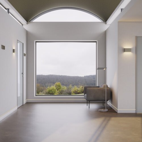 corredor de hotel em tons de cinza e branco com vista para uma floresta